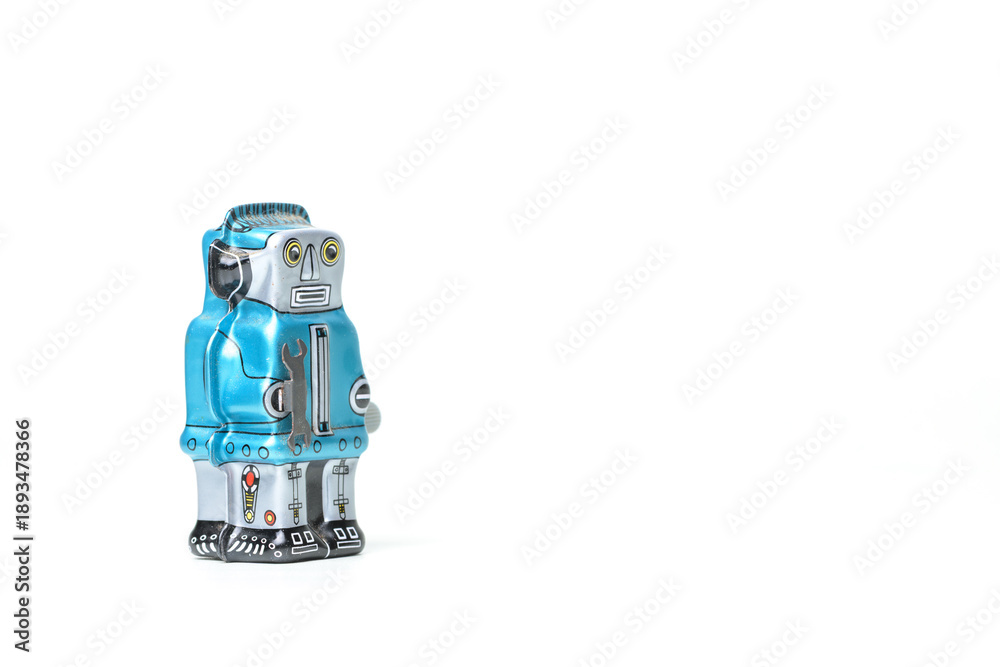 Fototapeta premium 白背景に置かれた青いブリキのロボット レトロなおもちゃ 右側にコピー用スペース