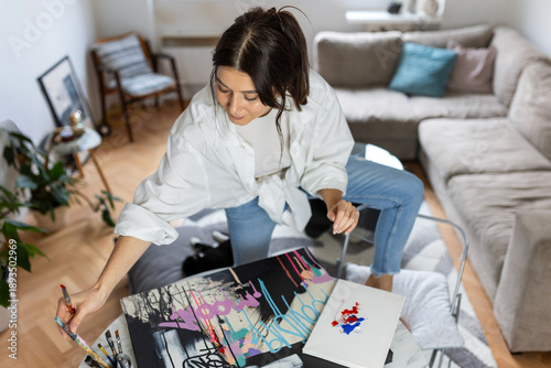 Bilde på lerret High-angle shot of a female artist painting on canvas in a modern home studio
