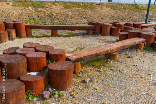 Valokuva Natural wooden playground area with log seating and play elements in modern urban park surrounded by city buildings