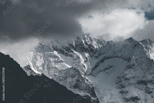 snow covered mountains in winter with low dark clouds