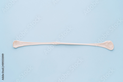 Canvas Print Stretched chewing gum strand on blue background, elasticity concept