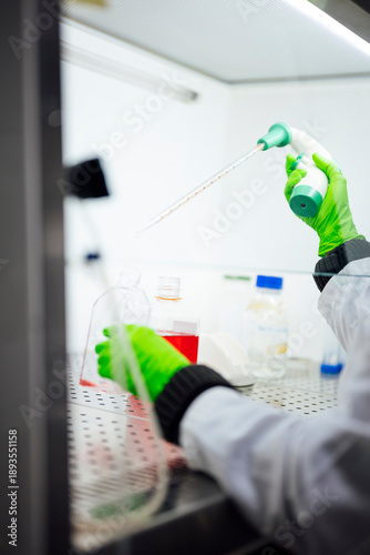 Scientist analyzing liquid with pipette in biology laboratory