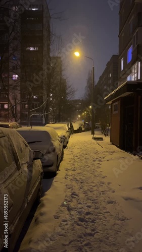 Snowfall during the night in city streets suburbs