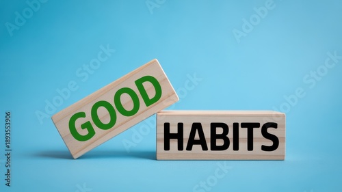 Wooden blocks with the words GOOD and HABITS on a bright blue background, symbolizing positive routines and personal development.