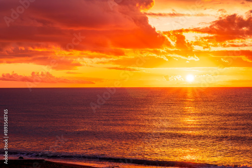 Dramatic seascape of sunset or sunrise sky with clouds during morning or evening. Dramatic sunset over the sea with orange clouds and sun above ocean water