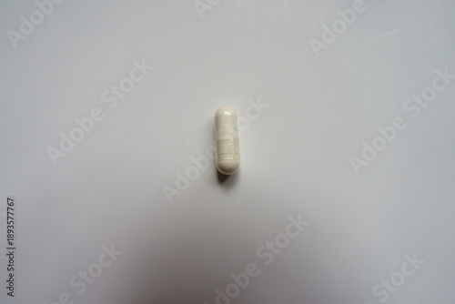 Top view of one white capsule of melatonin dietary supplement