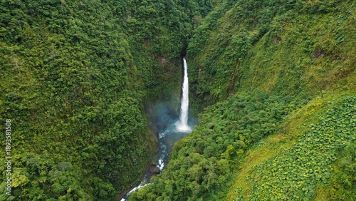 Wallpaper Mural Tall rainforest waterfall surrounded by lush green cliffs and mist in Costa Rica. Torontodigital.ca