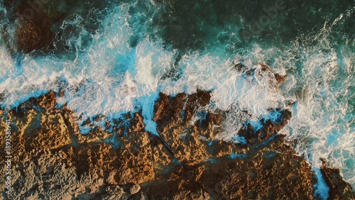 Waves breaking on rocky shore with turquoise sea at Crocodile Lagoon in Mexico.