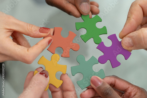 Foto Diverse team hands joining colorful puzzle pieces for inclusion and equity initi