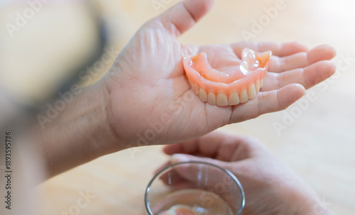 Photos Rear view of flexible nylon denture on senior female hands