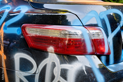 Φωτογραφία A car with a rear light and a blue graffiti-like design on its side