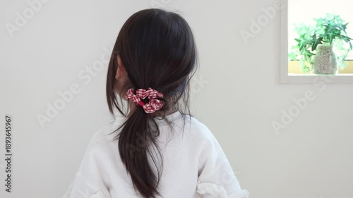 ポーにーテールに結んだ女の子が首を動かすの後ろ姿（5歳、日本人、黒髪）