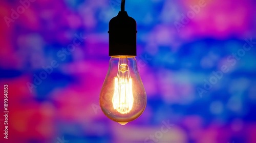Vintage Edison Light Bulb Glowing on Colorful Abstract Bokeh Background Design