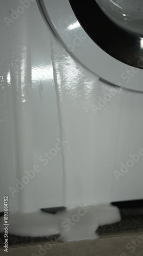 Broken washing machine in the bathroom.
Electrical repair.
Soapy water leaking from the washing machine.