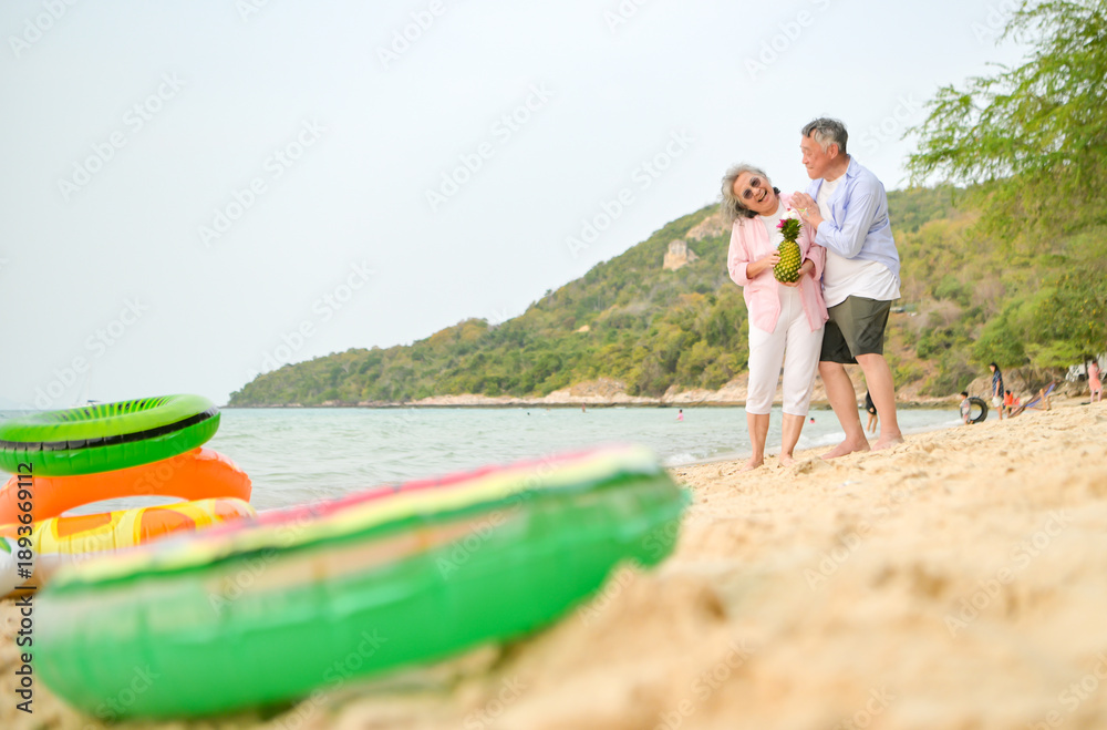 Fototapeta premium In holiday, Senior couple standing together and smiling while holding fruit