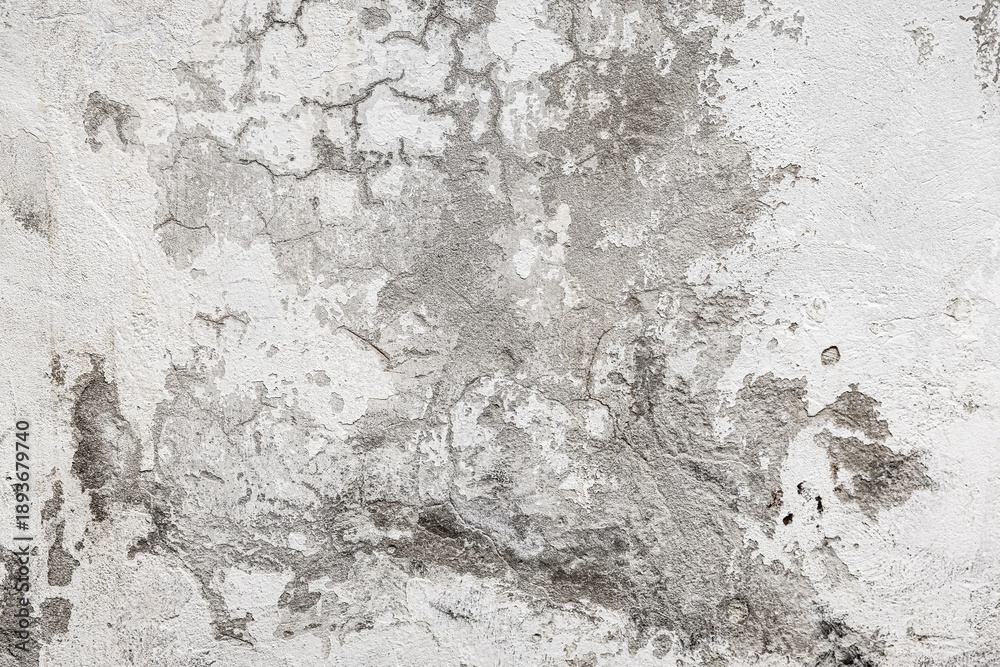 Obraz premium A close-up of a dirty white wall featuring smudges, dark stains, cracks, and scratch marks. Rough texture and aged surface with ample copy space