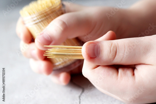 Bild auf Leinwand A jar of bamboo toothpicks in children's hands. Oral hygiene.