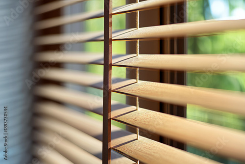 Sunlight passing through wooden window blinds creating warm shadows and soft light patterns in a modern interior