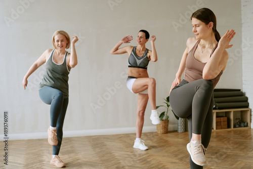 Billede på lærred Three young adult women, including two Caucasian and one Black woman, exercising