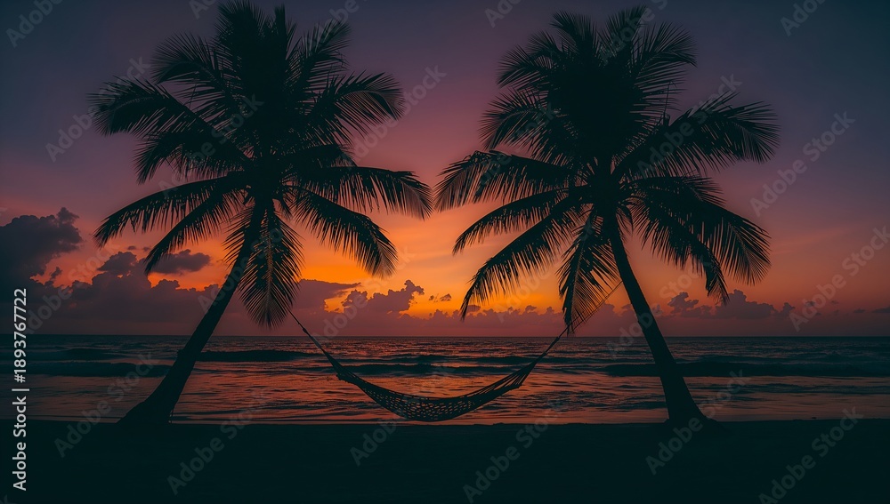 Obraz premium Silhouette of two palm trees with a hammock at sunset