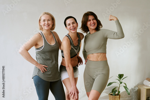 Schilderij op canvas Three Caucasian middle aged women standing together smiling and posing in active