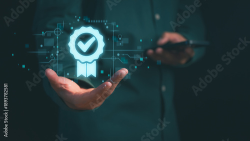 Professional hand holding digital quality assurance icon. Concept of ISO certification, standard guarantee, business compliance, warranty, and premium service verification on virtual screen.