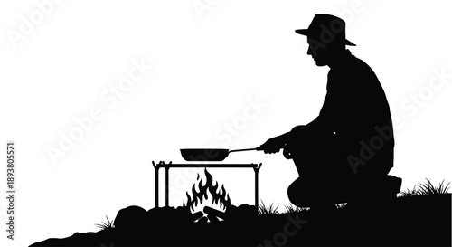 Silhouette of a man cooking over an open fire outdoors