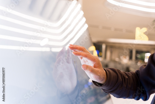 Bild auf Leinwand Hand touching a transparent digital screen in a modern shopping mall interactive