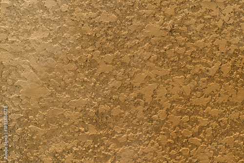 Gold tan stucco wall texture background with rough knockdown plaster surface for architectural design interior home decor or construction material close up