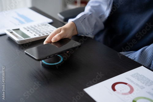 Fotografie Woman charging smartphone by using magnetic wireless charger
