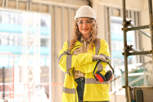 Photography Woman construction worker shows thumbs up while wearing safety gear and holding