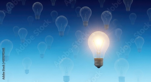 A glowing light bulb against a blue background with other light bulbs scattered around.