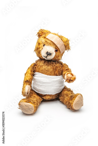alter Teddybär mit Wundverband und Heftpflaster