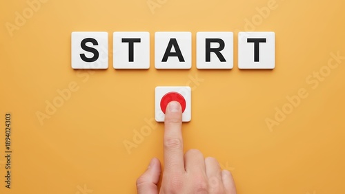 A generic pressing a red button below white tiles spelling start on a bright orange background