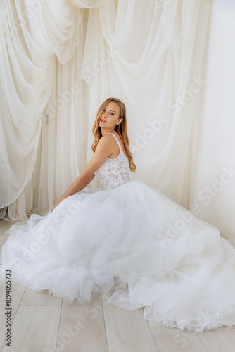 Beautiful girl in a white long luxurious wedding dress. Model bride posing in a gentle location