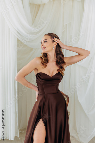 Portrait of an adult girl in a lush chocolate brown dress. Luxurious dresses for festive events and parties