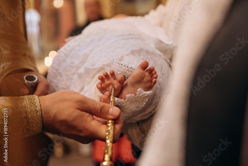 A close-up photo of a child's leg in the church during baptism. Children's christenings. Traditions for children