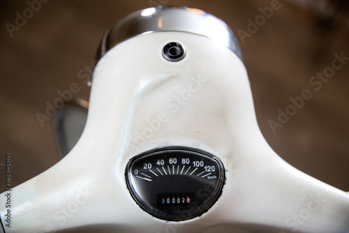 White vintage scooter's speedometer and odometer display a low mileage
