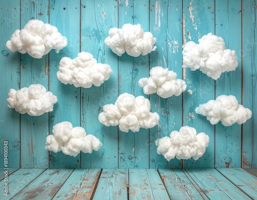 Decorative white cotton clouds suspended against a rustic, distressed teal wooden background.
