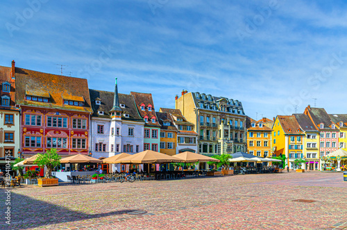 Mulhouse cityscape, typical houses colorful buildings and street restaurant outdoor café on Place de la Reunion square in old town Mulhouse city historic centre, Alsace Grand Est region, France