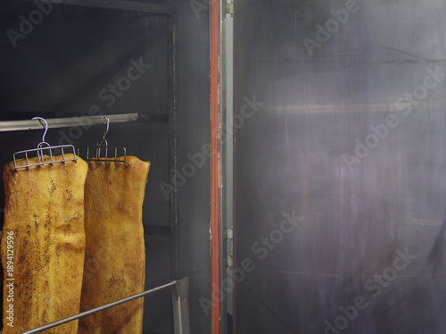 Photos Slab bacon hanging in a smoker oven