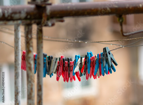 Fotografie Multicolored clothespins get wet in the rain.