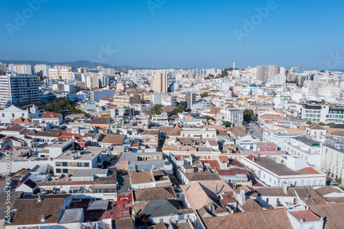 People can see the rooftops and buildings of Faro while enjoying a clear day in Algarve. The city showcases a mix of modern and traditional architecture
