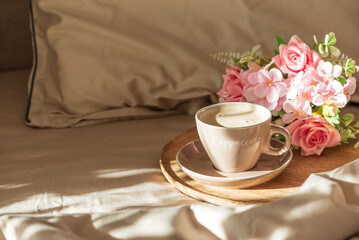 Cappuccino Cup and Flowers on Tray with Satin Bedding in Sunlight. Valentine's or Mother's Day Celebration