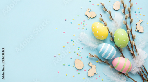 Step into spring with top view capturing essence of Easter colorful eggs, charming bunny, pussy willow blossoms, sugar sprinkles, pastel blue background, offering ideal canvas for your text or promo