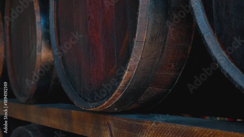 Close-Up of Stacked Aging Barrels on Distillery Shelf