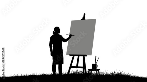 Silhouette of an artist painting on a canvas with an easel