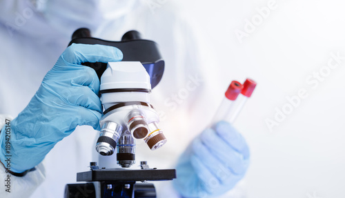 Quadro em tela Banner Scientist in lab coat analyzing samples with microscope and test tubes