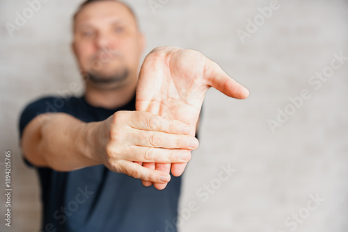 Fotografía Man doing therapeutic exercises, streching his wrist