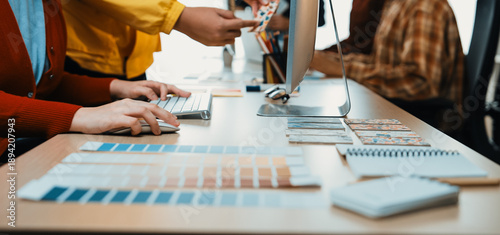 Billede på lærred A vibrant workspace shows creative professionals actively collaborating, sharing color samples, and engaging in a productive design process at a modern office desk setup